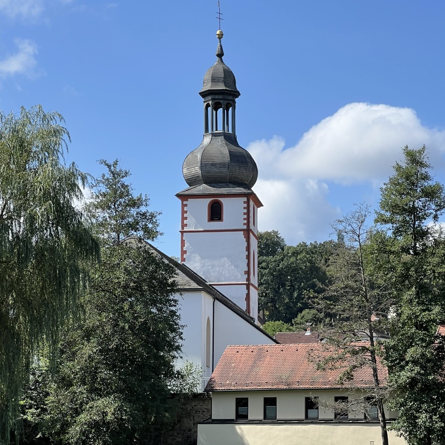 Kirche von Marktschorgast mit ihrem Zwiebelturm, umgeben von Bäumen